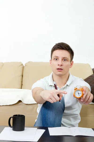 Портрет человека, указывающего на часы, теряющие время — стоковое фото