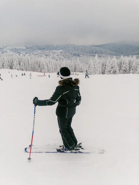 山の斜面の上に立って女性スキーヤー — ストック写真