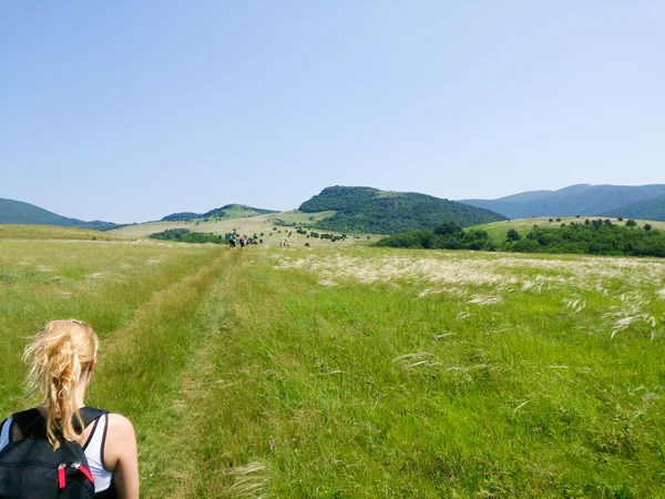 Frau im Stehen auf dem Gipfel der Alm in den Bergen und Blick auf — Stockfoto