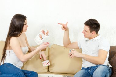 Young adult couple fight over stupid card game