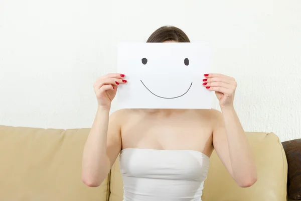 Girl holds happy face drawing — стокове фото