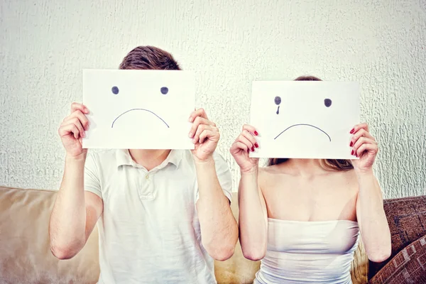 Unhappy young couple  in despair sitting on couch — Φωτογραφία Αρχείου