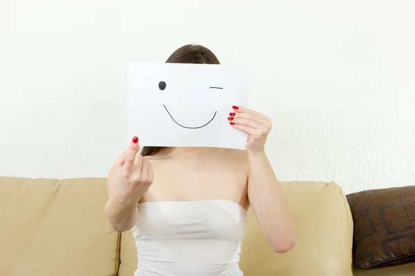 Chica sostiene dedo índice y sonriente ahogarse en papel . — Foto de Stock