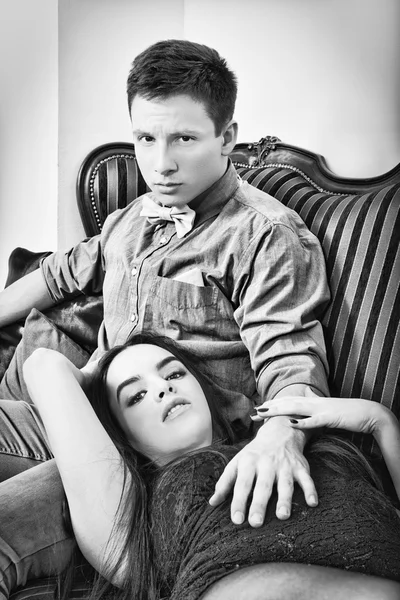 Young couple sitting on the couch, black  and white photography. — Stok fotoğraf