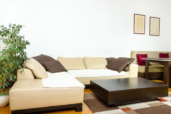 Ecke gelbes Sofa mit bunten Kissen und schwarzem Holzkaffee — Stockfoto