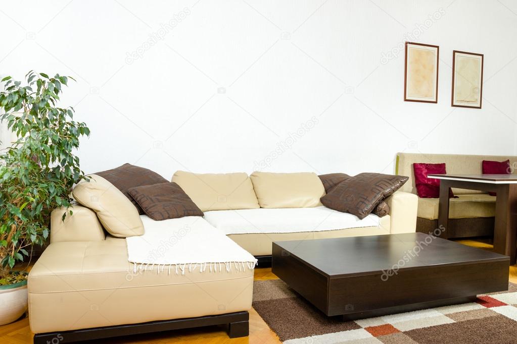 Corner  yellow sofa with colorful pillows and black wooden coffe