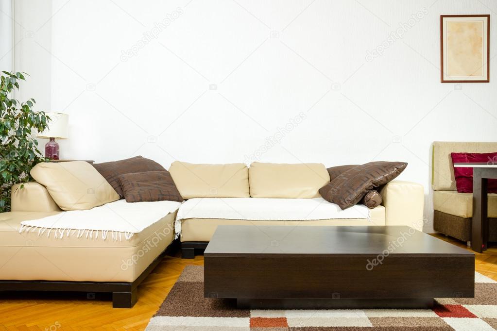 Close-up of yellow angular with pillows and low table in exclusi