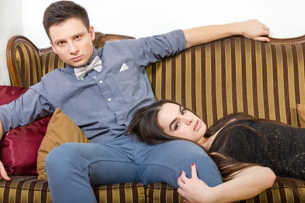 Attractive couple at ancient room sitting on couch or sofa — Stock Photo, Image