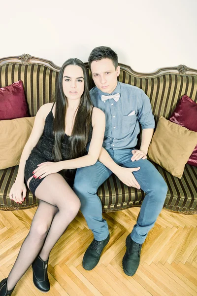 Attractive couple at ancient room sitting on couch or sofa — Stock Photo, Image