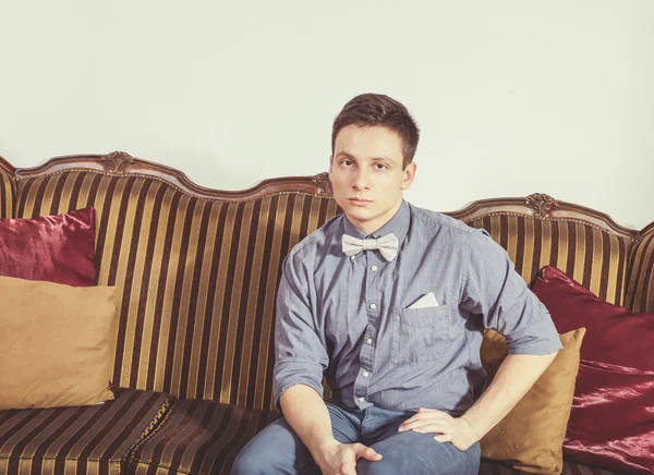 Serious person in shirt and bow tie resting on an old retro class — Stock Photo, Image