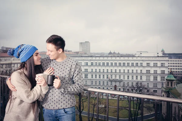 Couple happy in love hugging near railing with cups of tea or co — Φωτογραφία Αρχείου