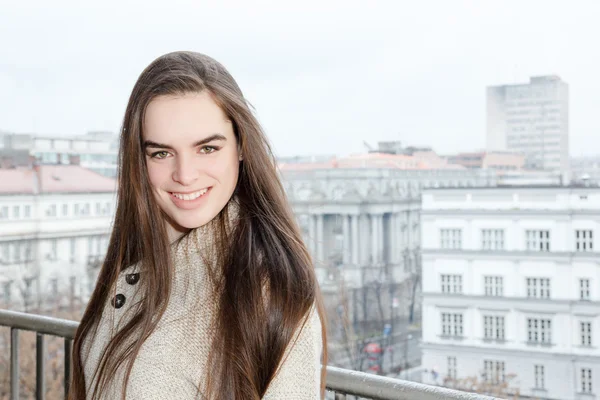 Smiling girl in the center of the city posing downtown — Stock fotografie