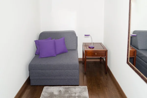 Comfy Gray Armchair with Purple Pillow near a Small Table — Stockfoto