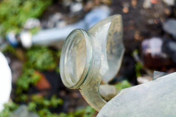 Photo of broken glass jar on junkyard