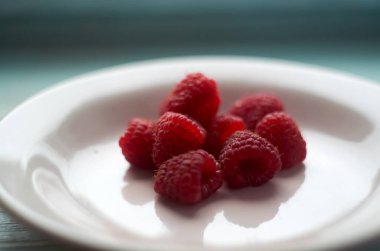 Beyaz seramik tabakta taze ahududu.