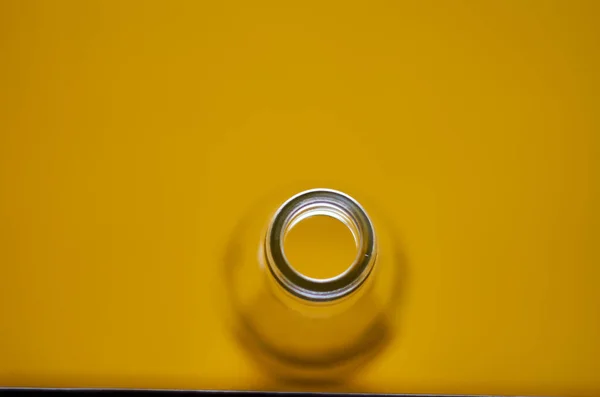 Foto van lege glazen fles. Gele achtergrond. — Stockfoto