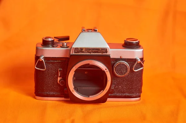 橙色背景上没有镜头的旧苏联相机 — 图库照片