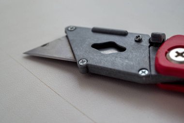 Kırmızı plastik saplı geri çekilebilir makina kesicisi beyaz üzerine izole