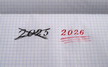 2025 yazısının üstünü çizmiş ve 2026 'nın altını çizmiş.