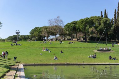 BARCELONA, İspanya - 21 Mart 2021: SABADELL şehrindeki PARC CATALUNYA 'nın çimlerinde oturan insanların görüntüsü