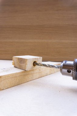 Tahtadaki delikteki matkap ucu ile bir ahşap matkabın görüntüsü