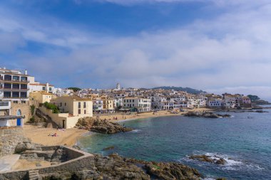 GİRONA, İSPAN - 31 Mart 2021 CALELLA DE PALAFRUGELL 'in farklı plajlarındaki insanlar koruyucu maskelerle güneşleniyor