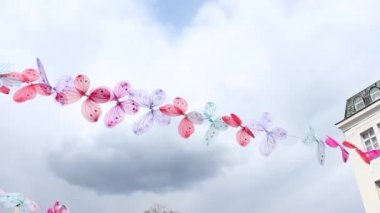 Şehirde ipte asılı duran farklı renkte kelebek süsü.