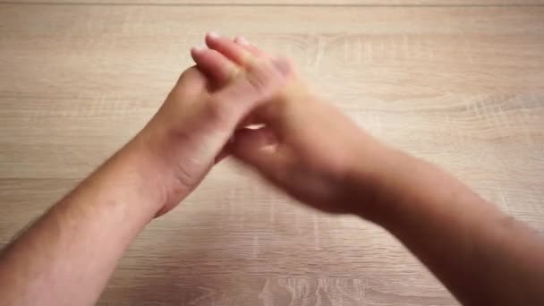 Zwei Hände eines Mannes, der sich auf einem Holztisch bewegt — Stockvideo