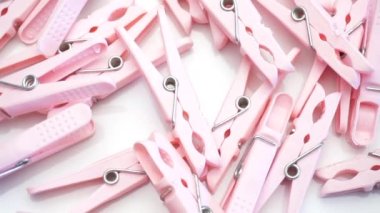 Pembe plastik cımbızları yakın plan beyaz zemin üzerinde döndürme, üst görünüm