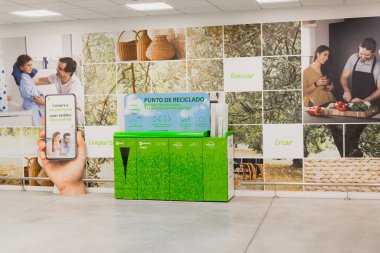 BARCELONA, İspanya - 4 Ağustos 2021 Leroy Merlin alışveriş merkezinin girişindeki yeşil geri dönüşüm kutusu