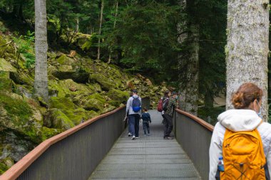 LLEIDA, İSPAN - 28 Temmuz 2021: Bossst kasabasındaki Aran Parkı 'nın doğal parkında, bir yürüyüş yolunda yürüyen koruyucu maskeli insanların görüntüsü