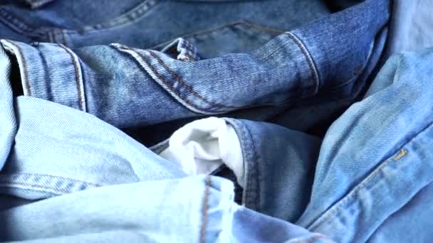 Close Van Gevouwen Blauwe Jeans Draaiend Een Roterende Achtergrond — Stockvideo