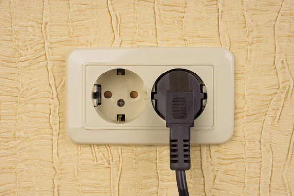 Toma eléctrica y enchufe en una pared — Foto de Stock