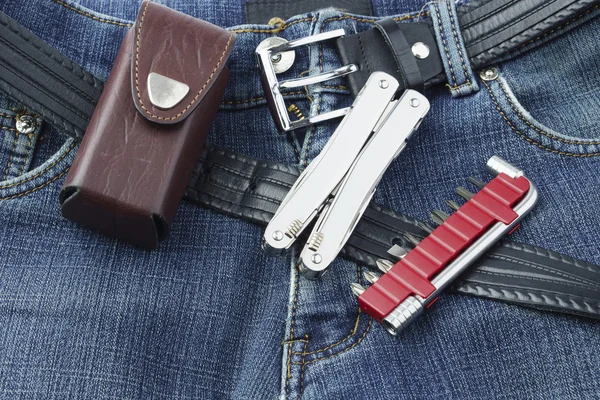 Blue jeans with stainless multitool knife and set of screwdriver — Stock Photo, Image