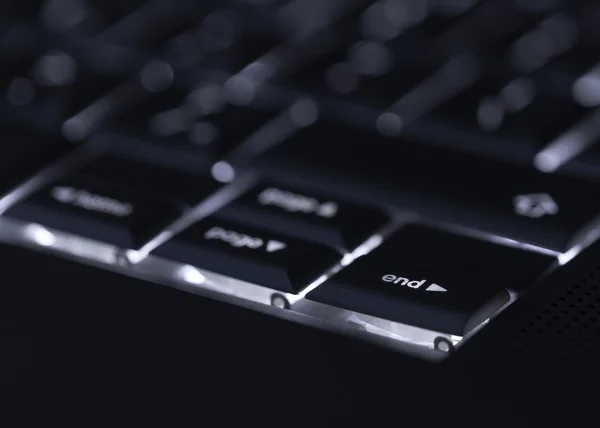 Nahaufnahme einer beleuchteten Computer-Laptop-Tastatur mit selektivem Fokus auf E Stockbild