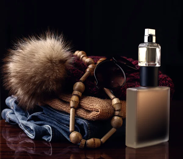 Garrafa de perfume e roupas femininas — Fotografia de Stock