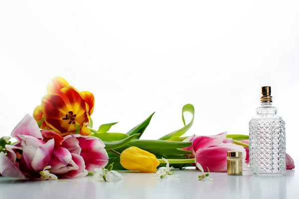 Parfymflaska med kronblad i tabell närbild — Stockfoto
