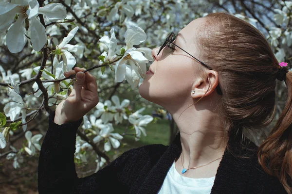 Porträt einer schönen Frau, die eine Blume riecht — Stockfoto