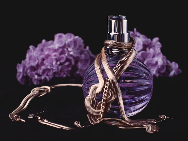 Perfume de mujer y flores púrpuras — Foto de Stock