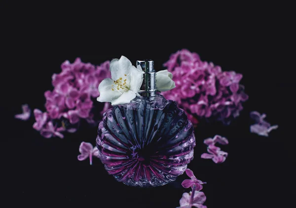 Духи и фиолетовые цветы — стоковое фото