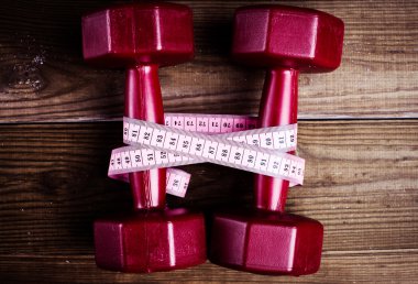 Kırmızı dumbell ve Fitness, kavram için kullanma ölçü bandı