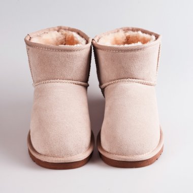 Kadınların koyun derisi botları beyaza izole edilmiş.