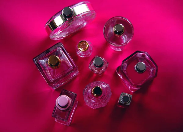 Botella con perfumes sobre fondo rosa — Foto de Stock