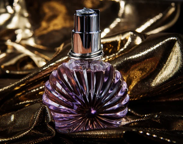 Sticlă de parfum pe fundal auriu — Fotografie, imagine de stoc