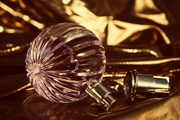 Parfümös üveg, arany háttér — Stock Fotó