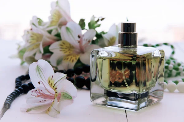 Perfumy z Czarnej Perły z kwiatami — Zdjęcie stockowe