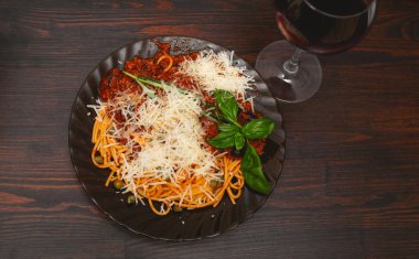 Bolonez makarnası ve ahşap zemin üzerinde kırmızı şarap.