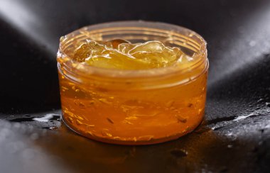 Siyah arka planda kavanozda salyangoz jeli