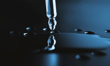 Mavi arka planda bir doz sıvı hyaluronik asit olan bir boru. Kozmetik konsepti. Metin için yer.