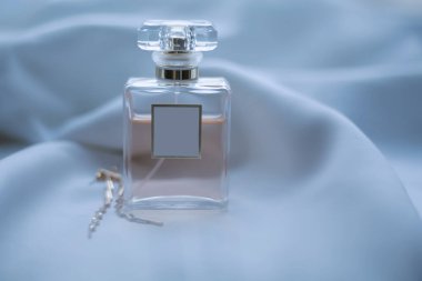 Hafif bir arka planda parfüm ve kadın mücevherleri